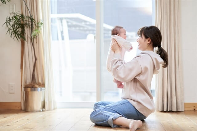 自宅で赤ちゃんに微笑むお母さん