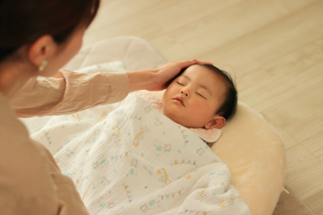 寝る子どもと寝かしつけるママ