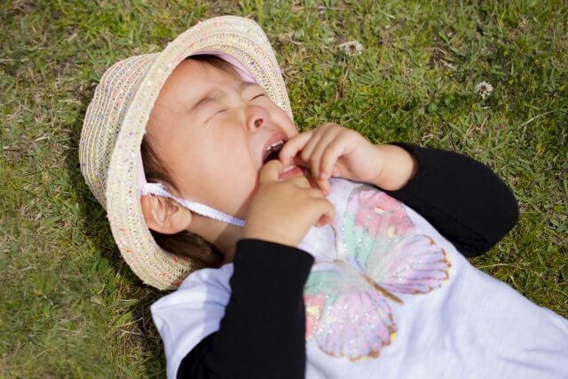 公園で寝そべって泣く女の子